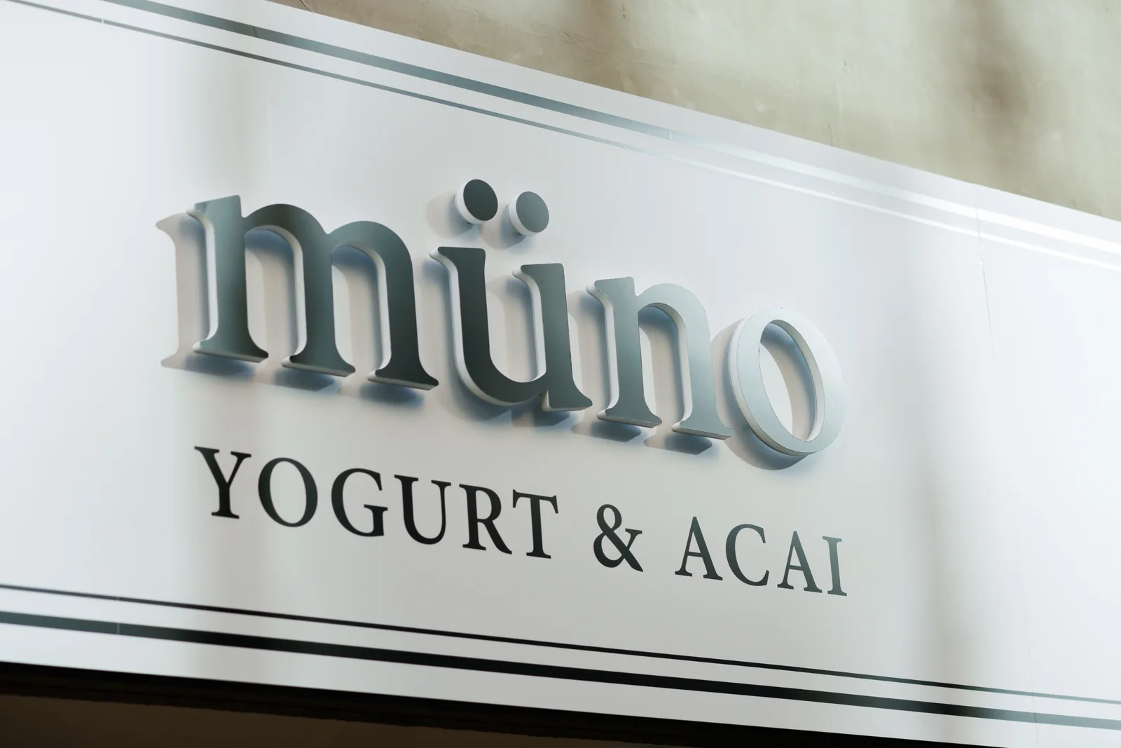 白い壁に掲げられたmüno YOGURT & ACAIの店舗ロゴ